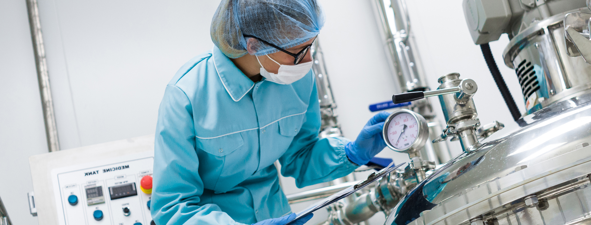 Food Safety Worker with Blue Suit and Hairnet Looking at Commercial Thermometer
